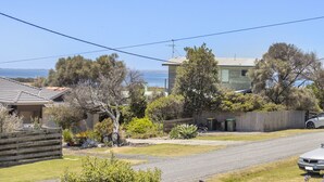 Área residencial com casas, uma rua e vista para o mar.