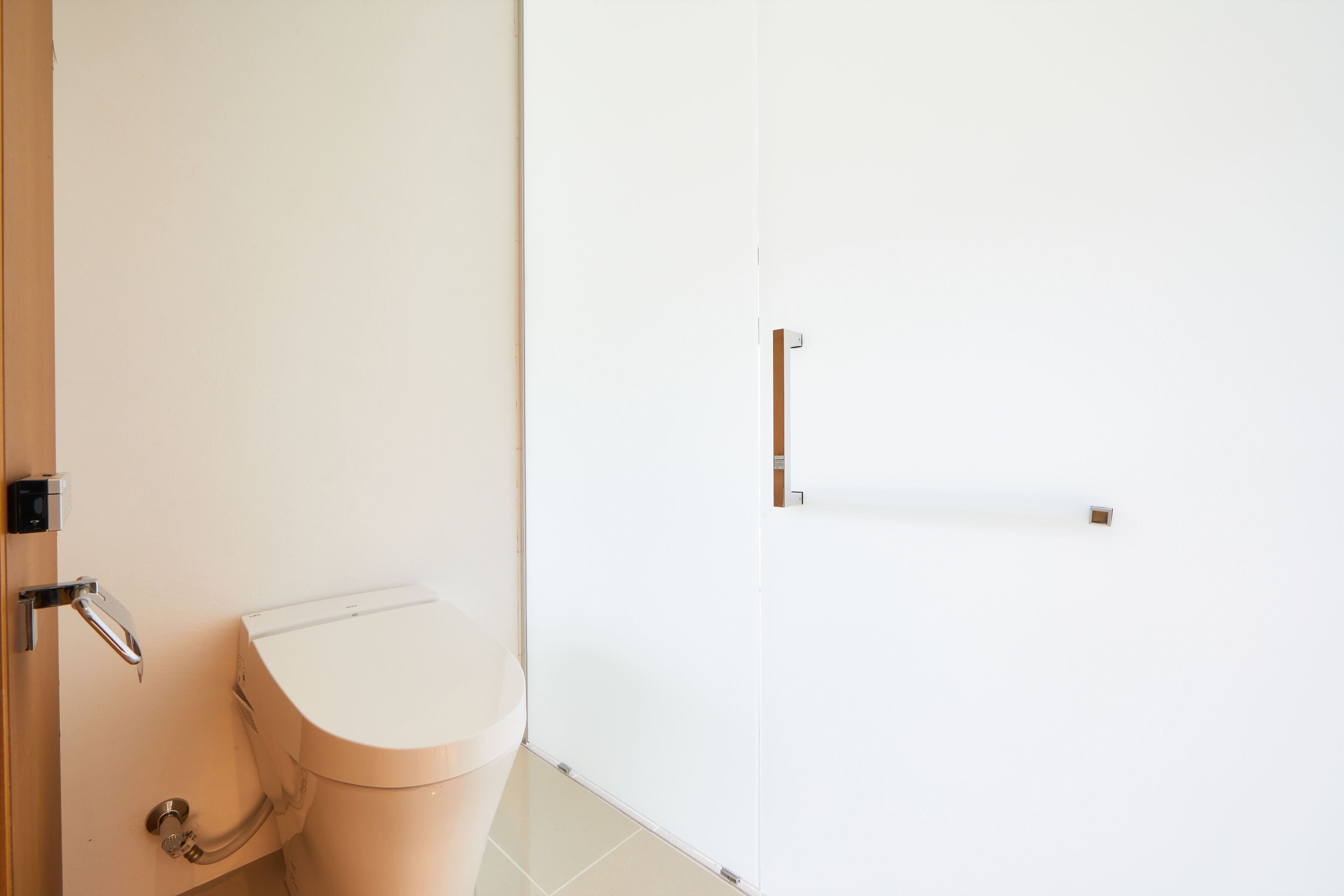 Et badeværelse med toilet, vask og dør.
