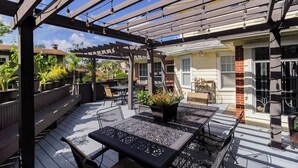 An outdoor patio with wooden pergola, metal tables, and chairs. - Sleeps 19 Guests ~ Prime Location Near Lake & FSC (Lakeland)