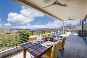 A dining area with a table set for four, overlooking a pool and mountains. - Modern Ranch Estate overlooking Valley of Moon (Santa rosa)