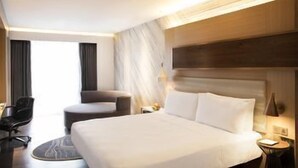 A hotel room with a large bed, a chair, a desk, and a window. - Le Méridien Goa, Calangute (Calangute)