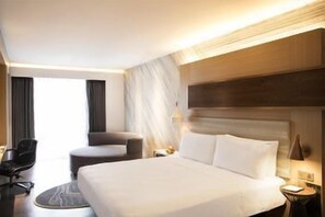 A hotel room with a large bed, a chair, a desk, and a window. - Le Méridien Goa, Calangute (Calangute)