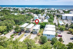 A coastal residential area with houses, a parking lot, and a view of the ocean.