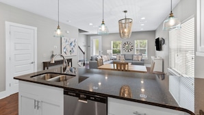 A modern kitchen with a central island, stainless steel appliances, and pendant lighting. - 30A Getaway - Beach, Dining, Shopping Nearby - Sleeps 12 (Santa Rosa Beach)