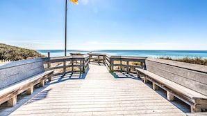 A wooden boardwalk leading to a beach with a flagpole and benches. - 30A Getaway - Beach, Dining, Shopping Nearby - Sleeps 12 (Santa Rosa Beach)