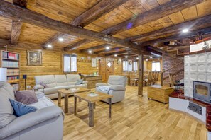 L’intérieur d’un chalet confortable, avec un plafond en bois, une cheminée et un coin repas.