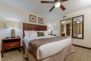 Relax in comfort with a large bed, bedside tables, and a ceiling fan.