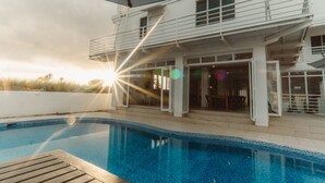 A modern house with a swimming pool, a covered patio, and a view of the sunset. - Sailors Beach Fiji (Nadi)