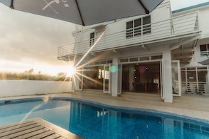 Una piscina al aire libre, sillones reclinables de piscina