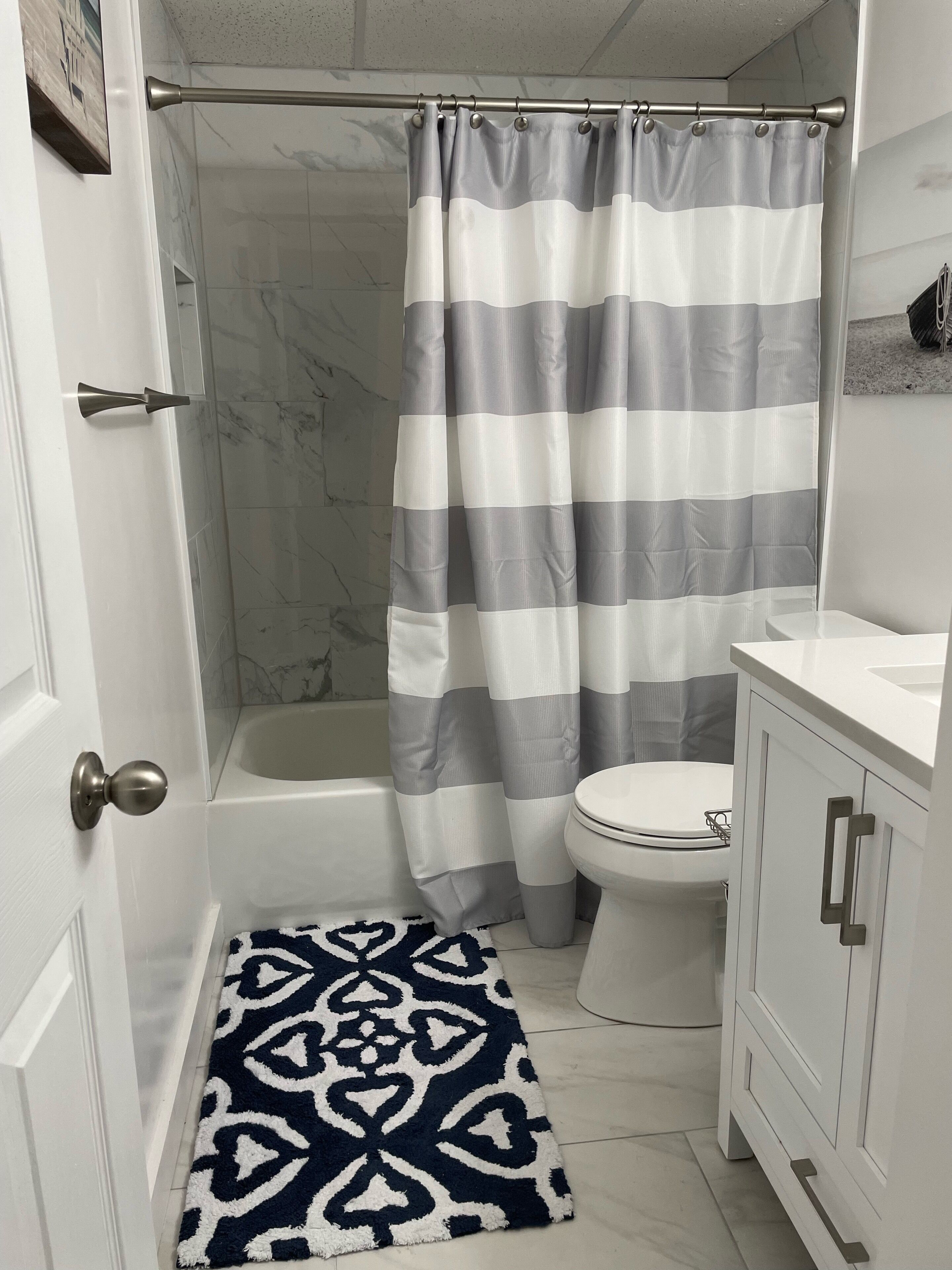 A bathroom with a bathtub, toilet, and a shower curtain.