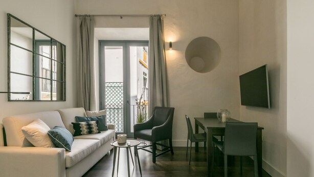 Een moderne woonkamer met een bank, salontafel en een eethoek.