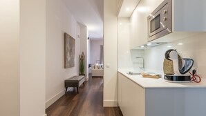 A modern kitchen with a built-in oven, a kettle, and a coffee maker on the counter. - Sierpes Luxury Premium de 2 -1 bedroom (Sevilla)
