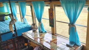 Ein gemütliches Interieur mit einem Bett, einem hängenden Affenschluff, einer Laterne und einem Fenster mit Vorhängen.