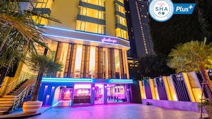 A hotel with a modern design, featuring a well-lit entrance and a visible staircase leading to the lobby. - SQ Boutique Hotel (Bangkok)
