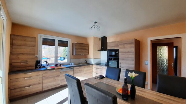 Una cocina moderna con armarios de madera, una mesa de comedor y sillas.