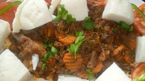 Un plato de comida con carne, verduras y pan blanco.