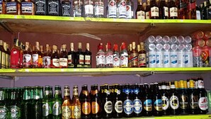 Estantes repletos de diversas bebidas alcohólicas, como whisky, cerveza y otros licores.