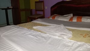 Una habitación con dos camas, una silla y un escritorio.