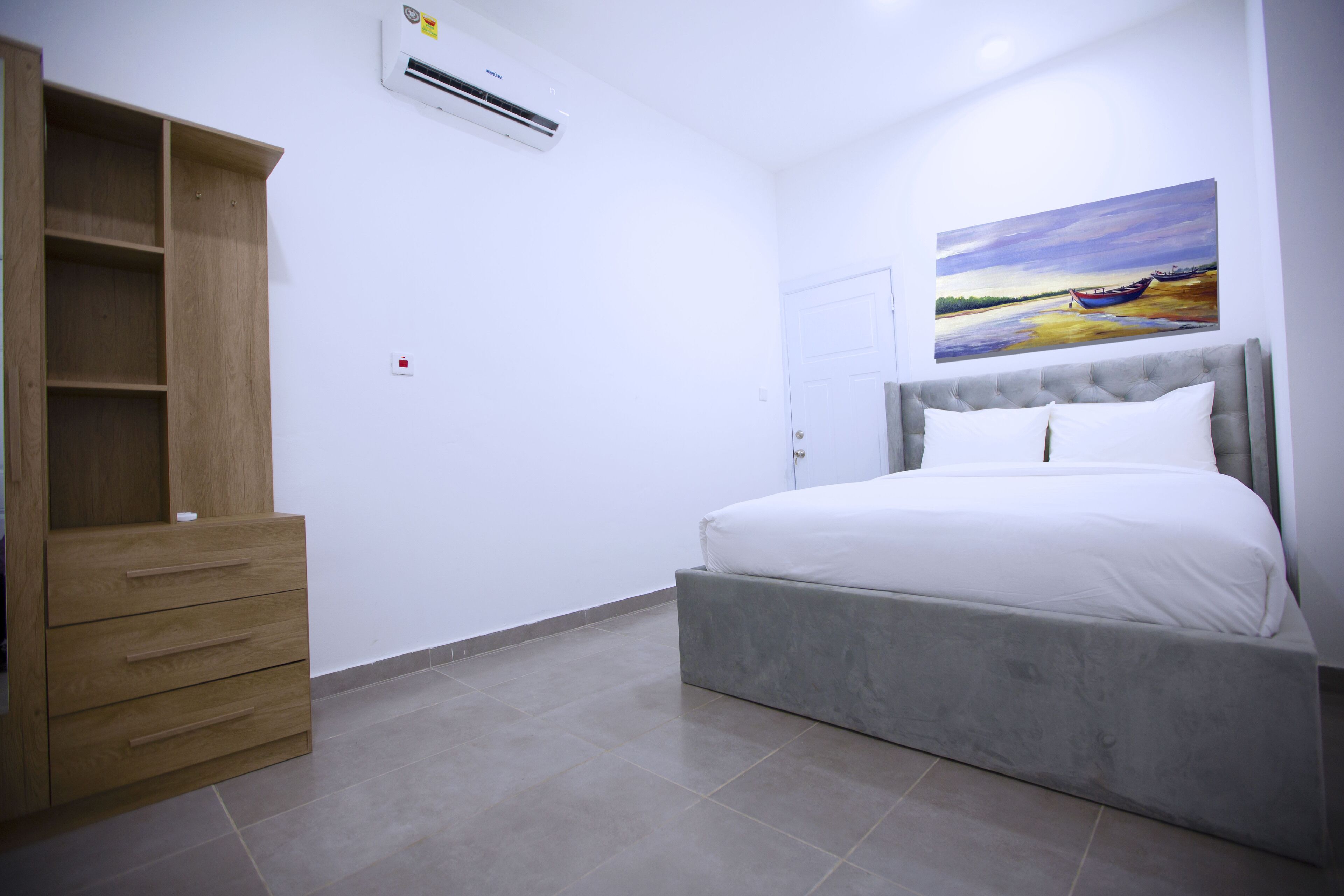 Um quarto com uma cama, um guarda-roupa e um quadro na parede.