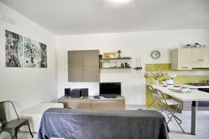A compact living space with a kitchenette, a dining area, and a seating area.