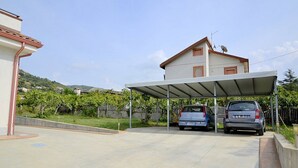 A covered parking area with two cars parked under a shelter. - Villa Olga E: A cozy and welcoming apartment that is part of a villa situated in a quiet location, a few minutes from the town center, with Free WI-FI. (Agropoli)