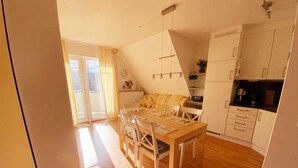 Una cocina luminosa con armarios de madera, una mesa de comedor y sillas.