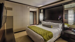 Une chambre d’hôtel moderne avec un grand lit, une table de chevet, un miroir et une vue sur le couloir.