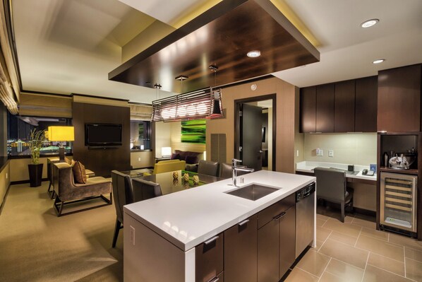 A modern kitchen with a central island, built-in appliances, and a dining area with a view of the cityscape.
