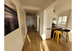 A modern kitchen with a wooden countertop, a yellow stool, and a view of the outside through a window. - Propriano: Sea view, Waterfront (Propriano)