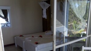 Una habitación con cama, una silla y una ventana.