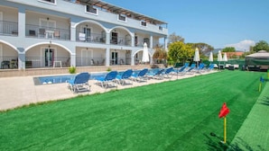 A hotel with a pool, multiple balconies, and a well-maintained lawn. - Brinswick Private Villa complex (Laganas, Zakynthos)