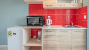 A compact kitchen with a microwave, kettle, and a small refrigerator. - Brinswick Private Villa complex (Laganas, Zakynthos)