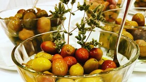 Un bol de vidrio lleno de frutas variadas y una ramita de hierbas.