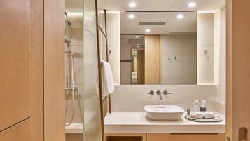 Een moderne badkamer met een grote spiegel, een wastafel en een douche.