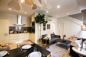 Una cocina moderna con comedor, sofá y escalera.