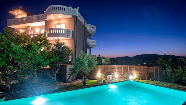 A modern house with a swimming pool, surrounded by trees and a wooden fence. - Panoramic Sea Views, Pool, Garden, BBQ, TableTennis, Playground, Hammock (Chania)
