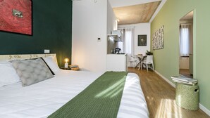 Quarto com cama, mesa de cabeceira e manta verde.