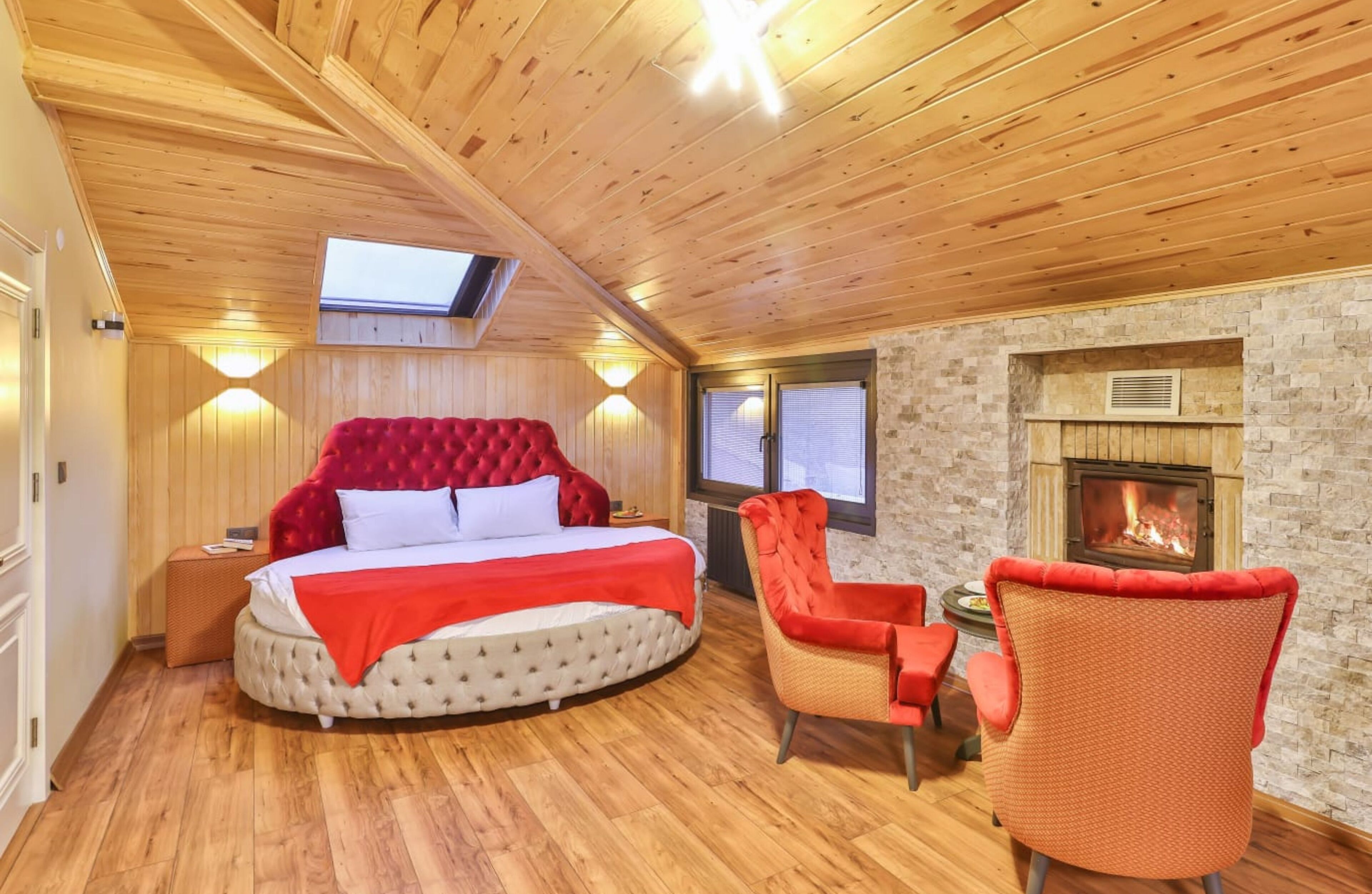 Una habitación acogedora con una cama grande, chimenea y tragaluz.