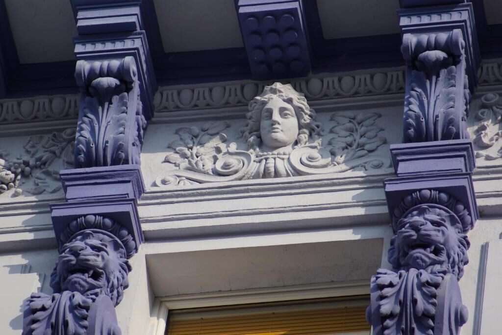 A building facade with ornate columns and a decorative relief.