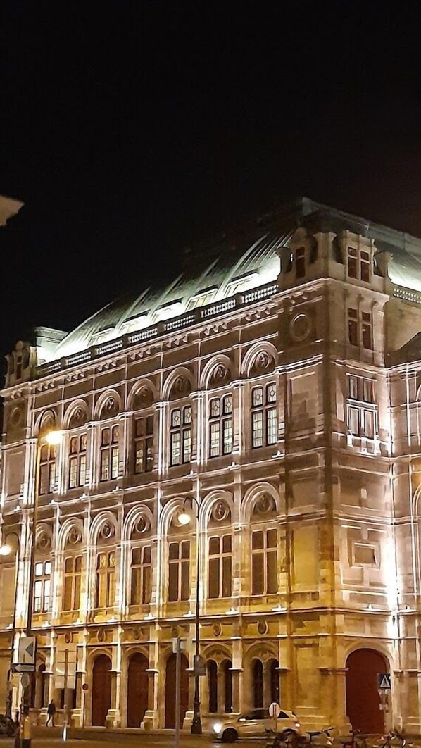 Un edificio histórico con arquitectura decorada, ventanas amplias y una entrada destacada.