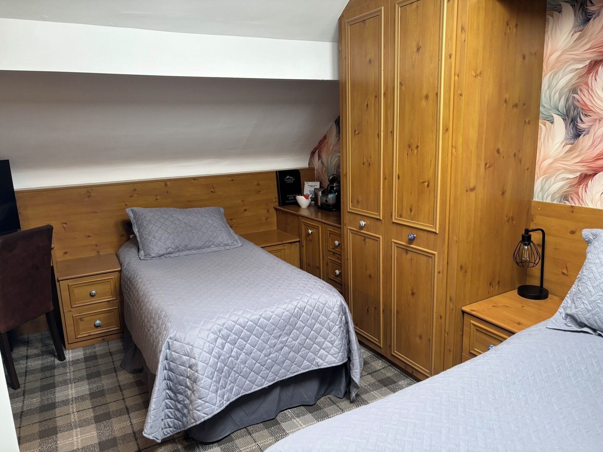 Une chambre à coucher avec un lit, une armoire, une table de chevet et un tableau accroché au mur.