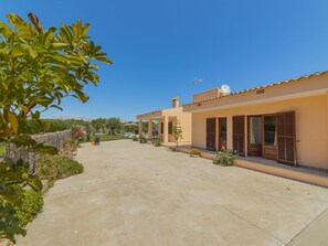 A residential property with a paved driveway, a covered patio area, and a view of the surrounding landscape. - Villa Can Segue · Villa with private pool in Alcúdia (Alcúdia)