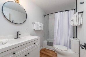 Ein modernes Badezimmer mit Waschbecken, Spiegel und Toilette in Weiß.