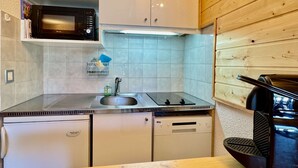 A compact kitchen with a microwave, sink, and built-in dishwasher. - 4-person apartment - all comforts <br>Skis at your feet (La Joue du loup - Le Devoluy)