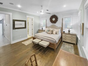 Cozy retreat with a large bed, nightstands, and a ceiling fan.