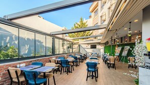 A restaurant with outdoor seating, brick walls, and a view of the city. - Sultan Hamit Hotel (Istanbul)