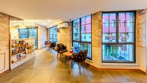 A spacious lobby with a marble reception desk, leather seating, large windows, and a tiled floor. - Sultan Hamit Hotel (Istanbul)