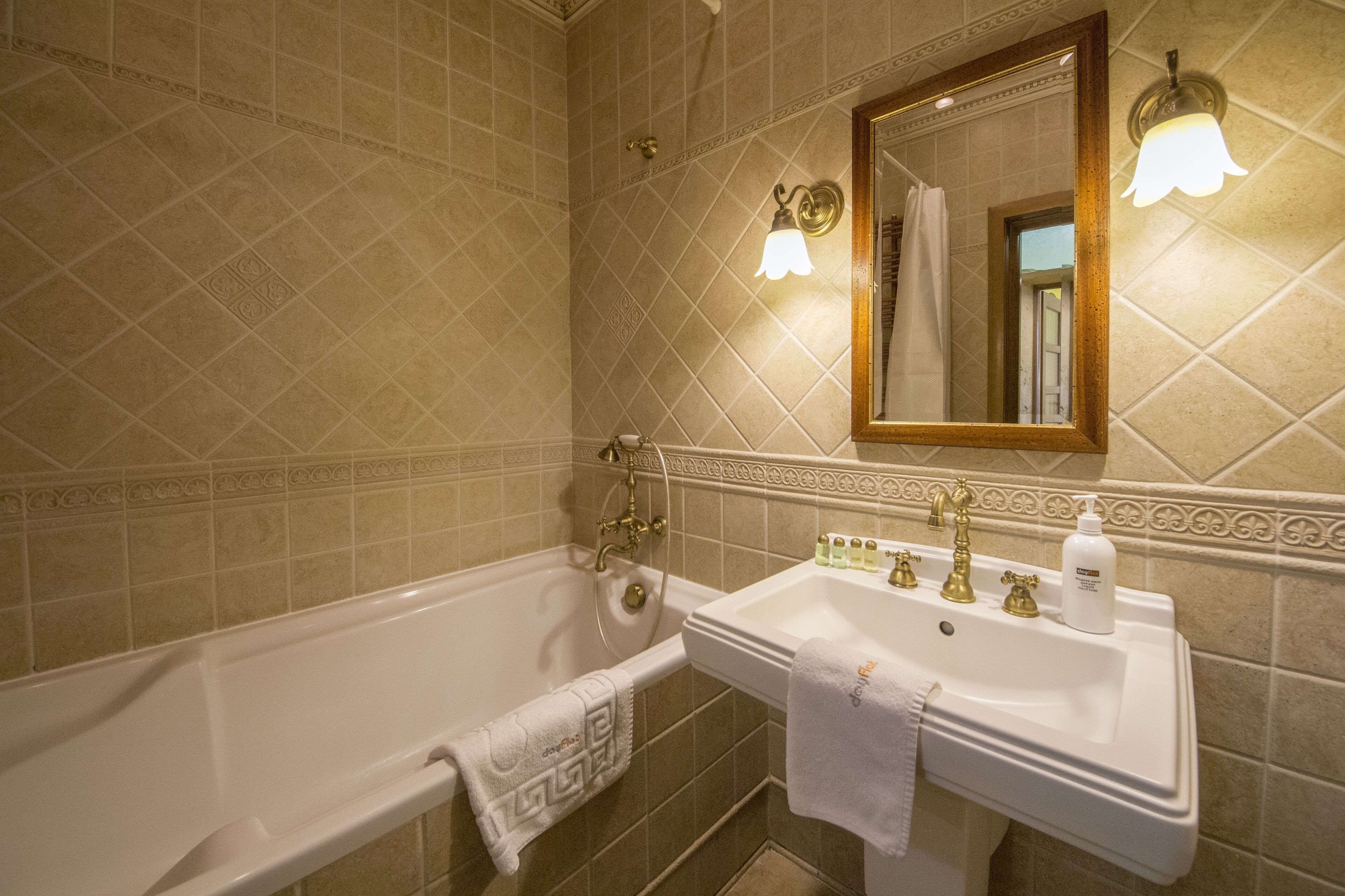 Een badkamer met een bad, wastafel en spiegel.