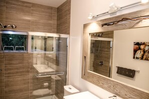Enjoy a refreshing shower in the bathroom, featuring a glass-enclosed shower and separate toilet.