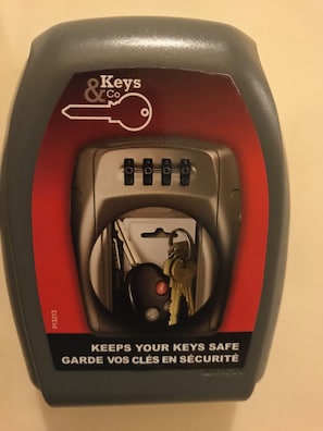 A keyless entry device with a red and black design, featuring a keypad and a slot for keys. - Room-welcome to our Establishment We wil (Rome)